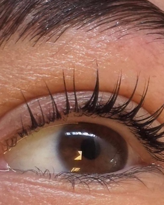 Een oog van dichtbij na een lash lift, de wimpers mooi omhoog gekruld